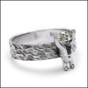 Sterling silver Unicorn Polar Bear ring. A Unicorn polar bear cast in sterling silver attached to a hammered 6mm ring. Side view. Designer statement jewellery from the Lloyd Henshall Collection